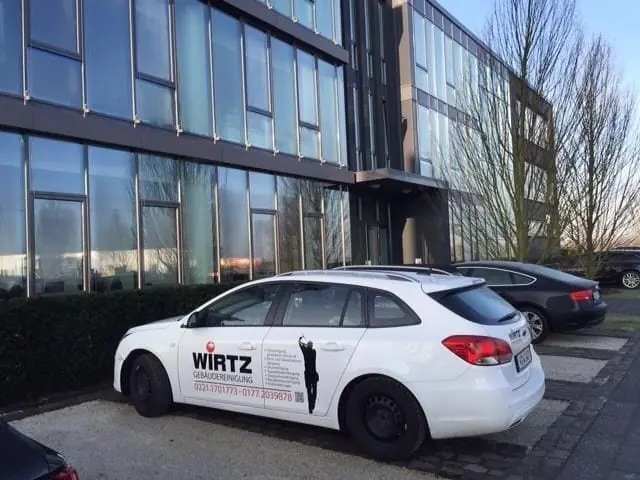 WIRTZ-Firmenwagen vor einem gläsernen Bürogebäude.