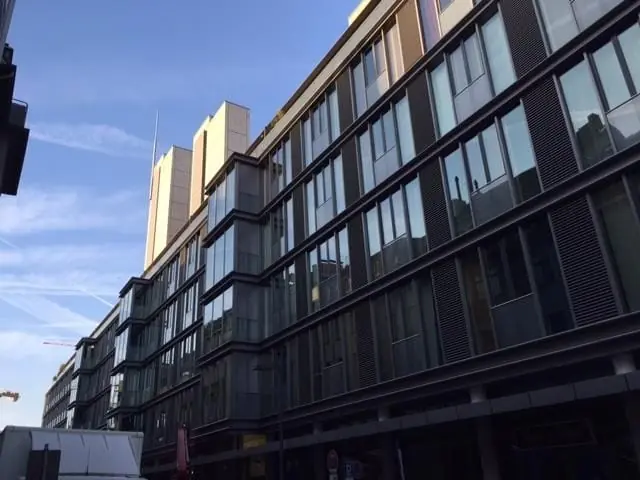 Bürogebäude mit großen Fensterbändern vor blauem Himmel.