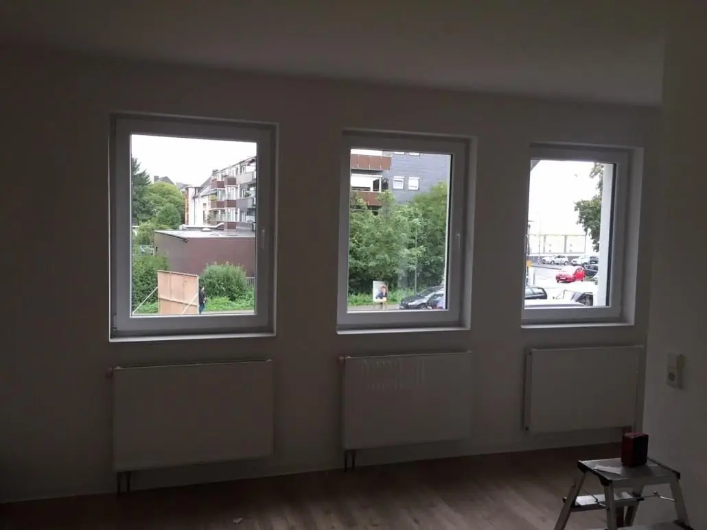 Leerer, frisch gereinigter Raum mit drei Fenstern.