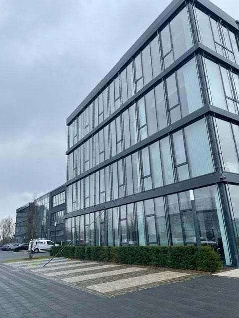Gläsernes Bürogebäude mit mehreren Etagen.