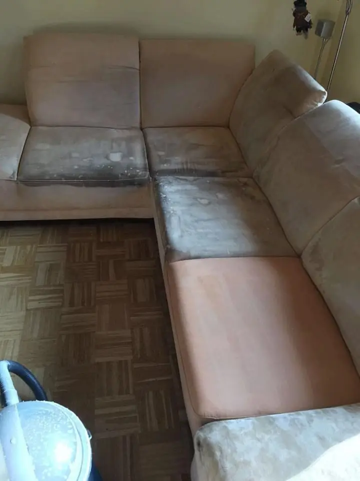 Ecksofa während der Polsterreinigung, ein Teil bereits sauber.